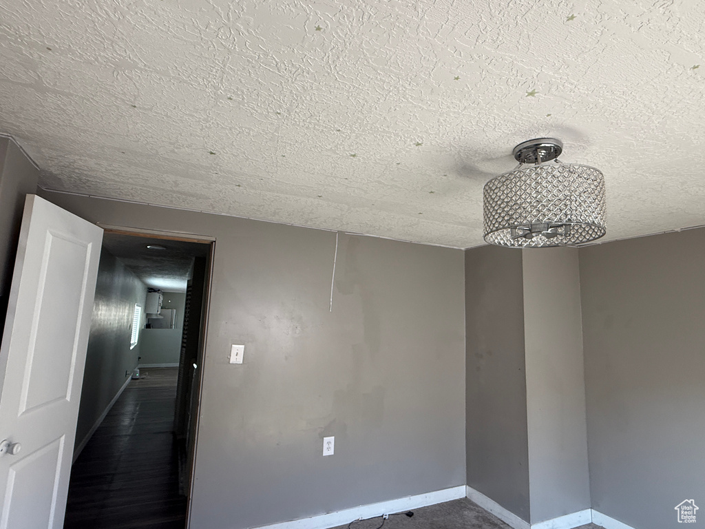 Spare room featuring a textured ceiling and baseboards