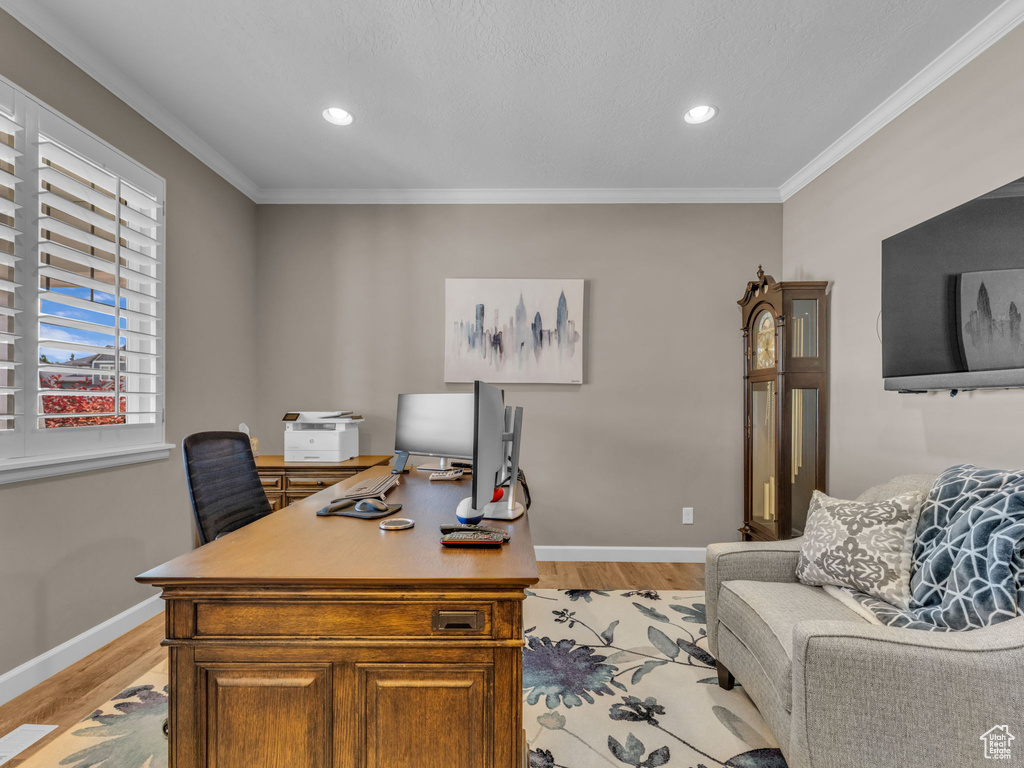 Office space featuring light wood-type flooring, baseboards, crown molding, and recessed lighting