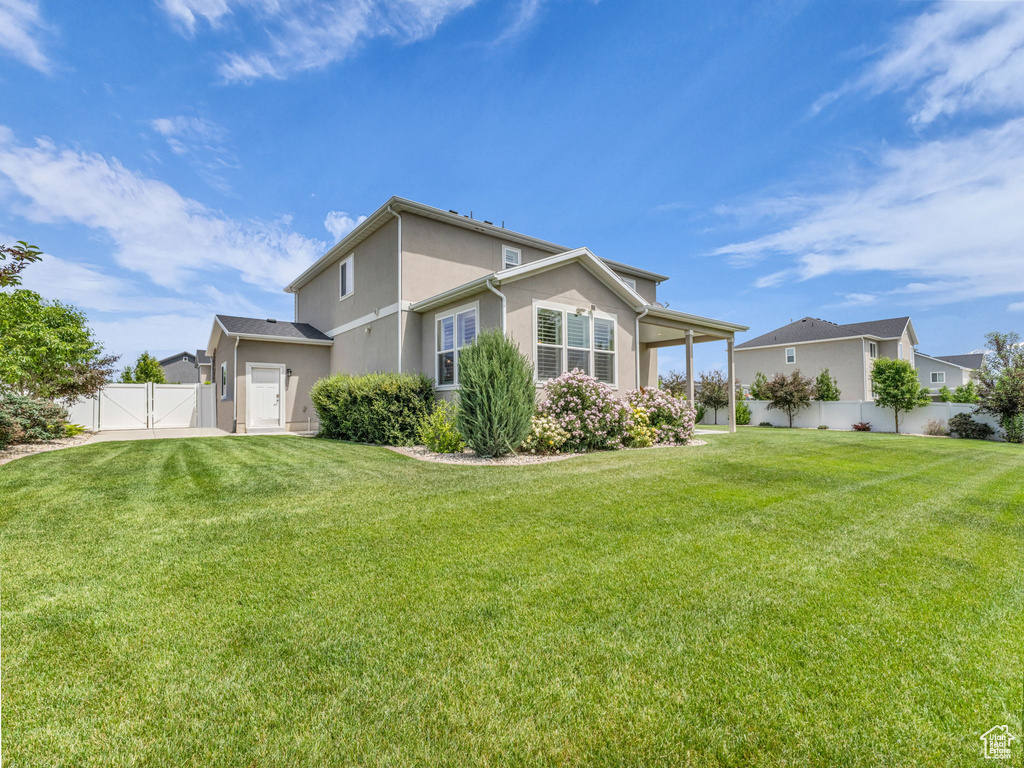 Rear view of property featuring a gate and stucco siding
