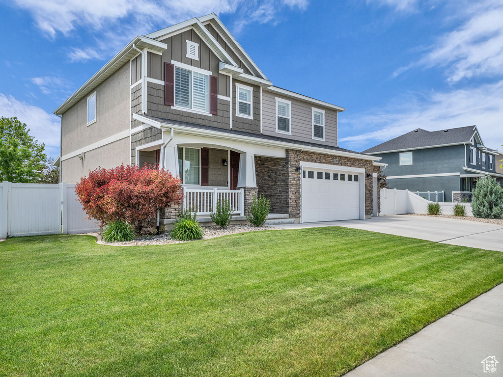 Craftsman house with covered porch, driveway, a gate, an attached garage, and board and batten siding