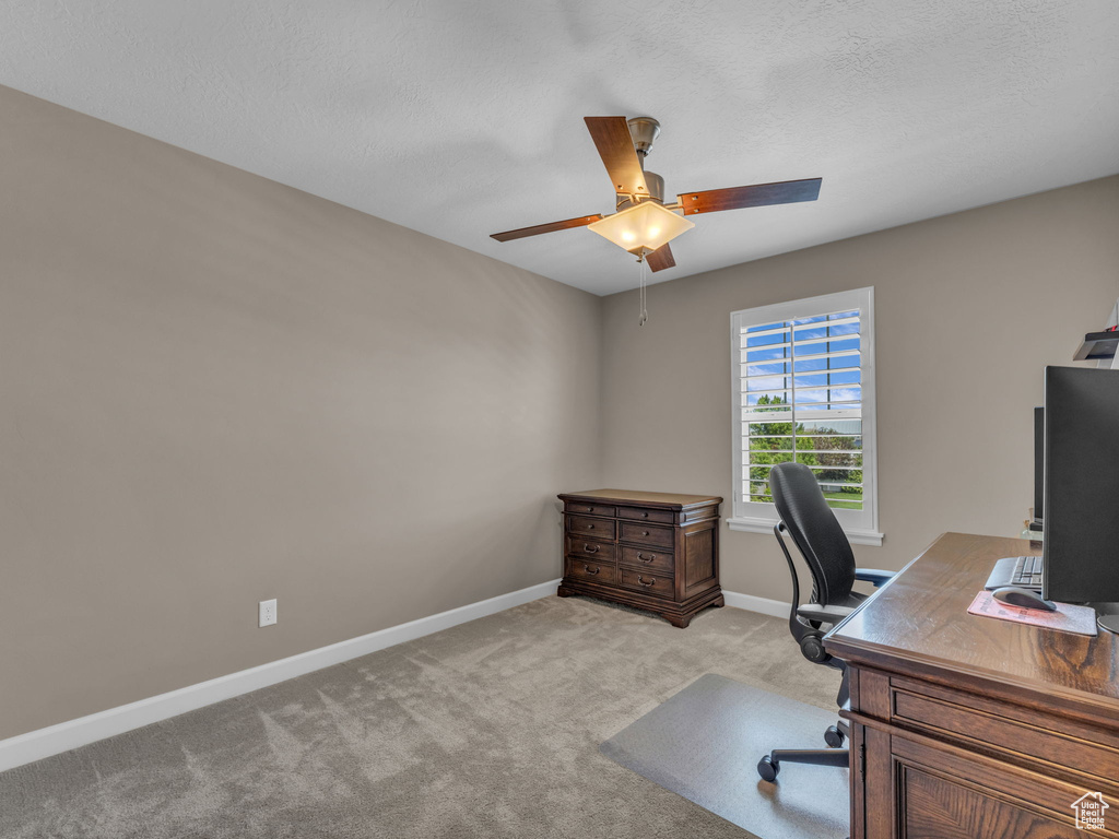 Office featuring ceiling fan, light colored carpet, baseboards, and a textured ceiling