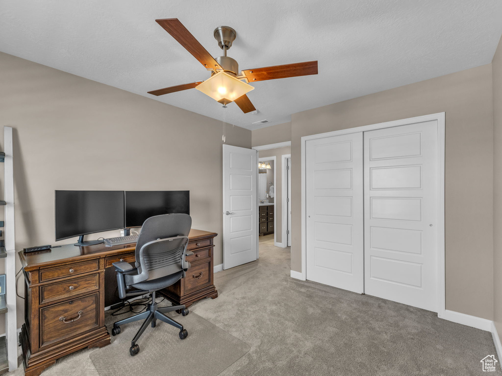 Home office with a ceiling fan, carpet flooring, and baseboards
