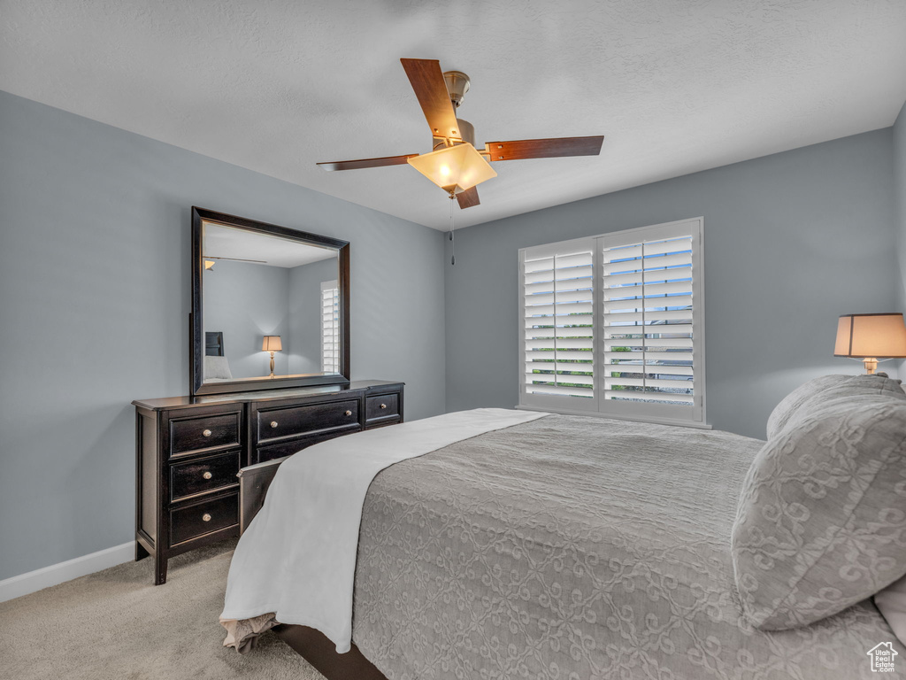 Bedroom featuring carpet, a ceiling fan, and baseboards