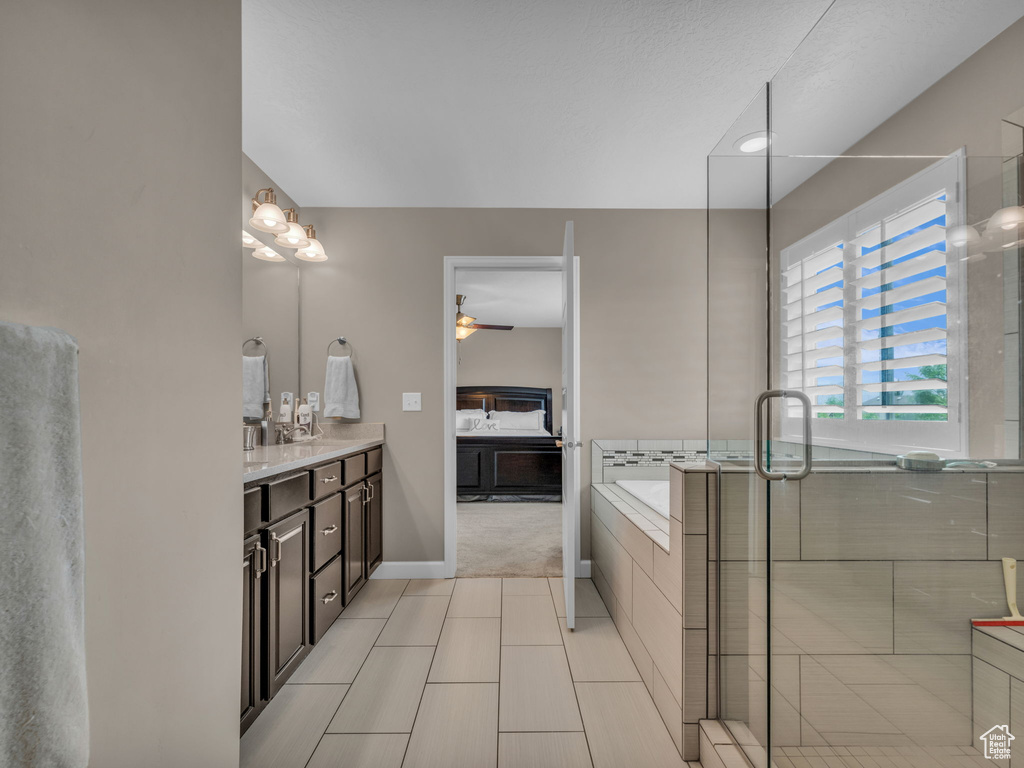 Full bath featuring vanity, tile patterned floors, a garden tub, a ceiling fan, and an enclosed shower