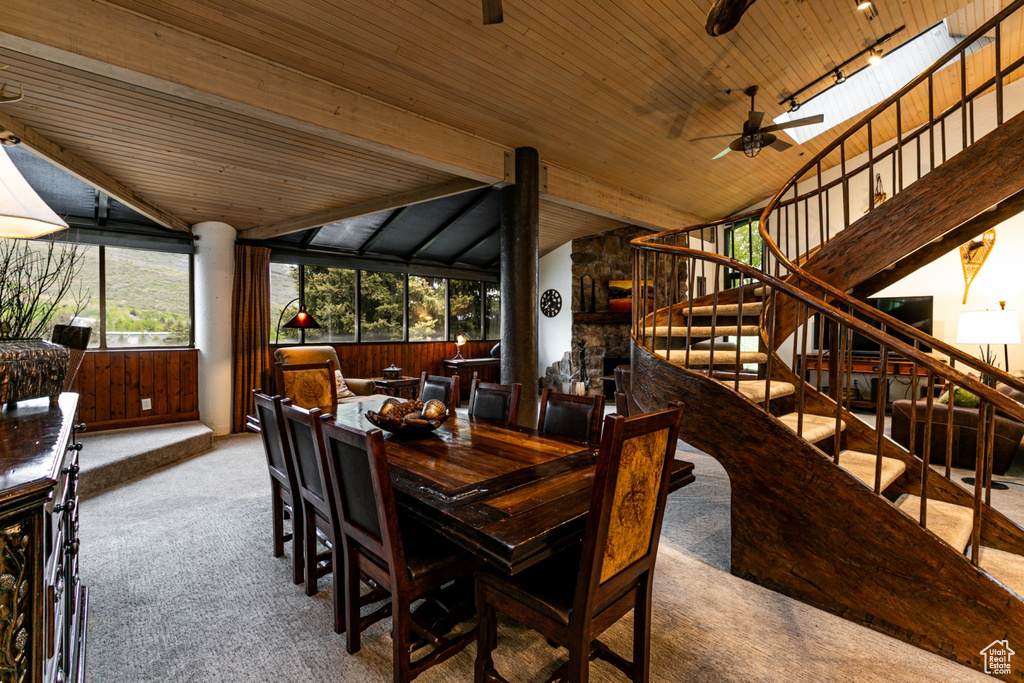 Carpeted dining room featuring lofted ceiling, stairway, wood ceiling, and a ceiling fan