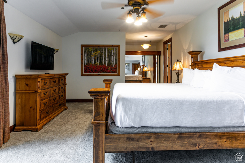 Bedroom featuring carpet flooring, vaulted ceiling, baseboards, and a ceiling fan