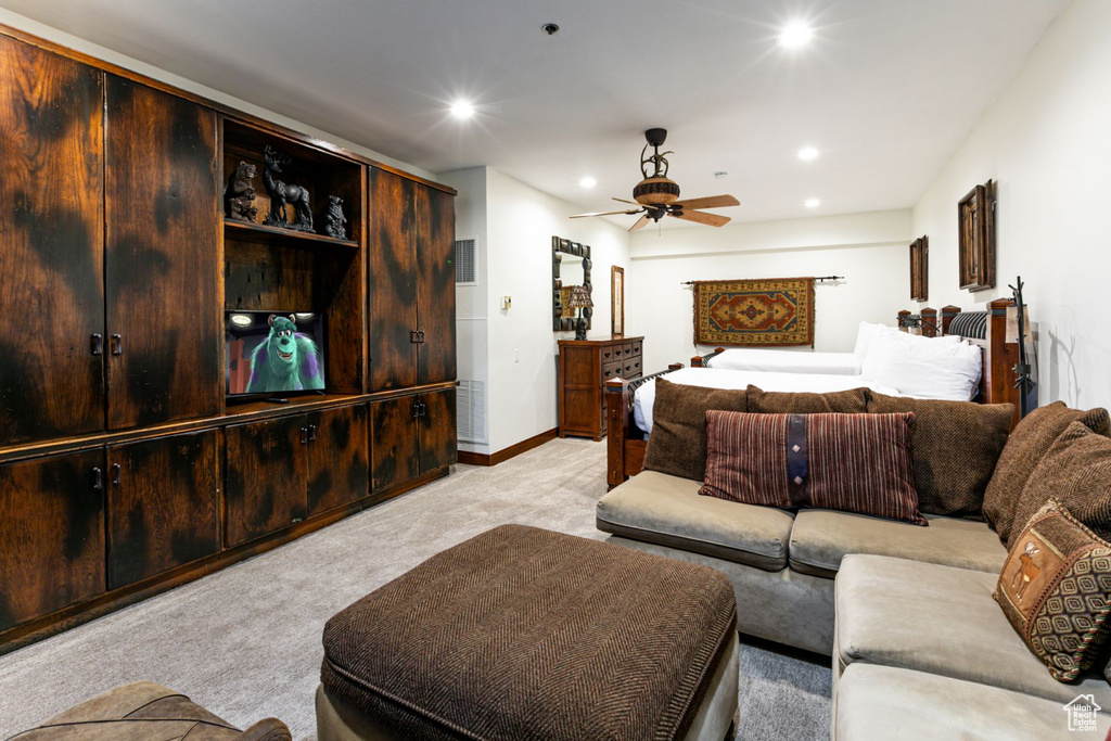 Living area featuring light colored carpet, a ceiling fan, and recessed lighting
