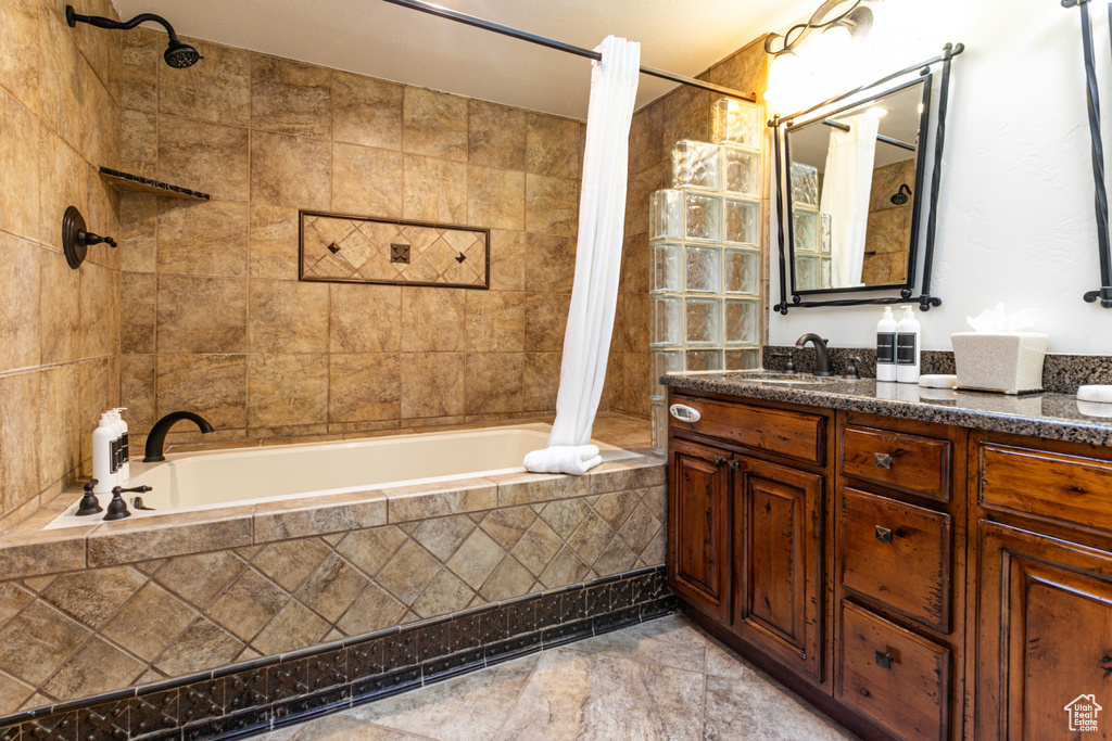 Full bath featuring tiled shower / bath combo and vanity