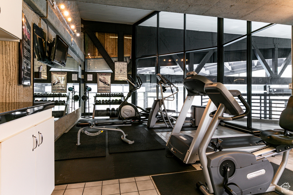 Exercise room with light tile patterned floors and plenty of natural light