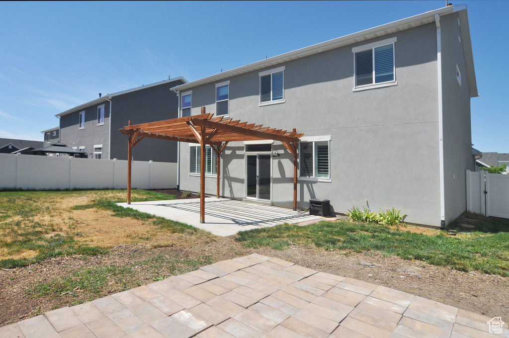 Back of house featuring a patio area, a pergola, stucco siding, and a fenced backyard
