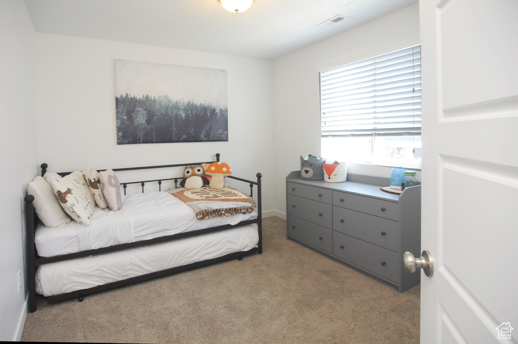 Bedroom featuring light colored carpet and baseboards