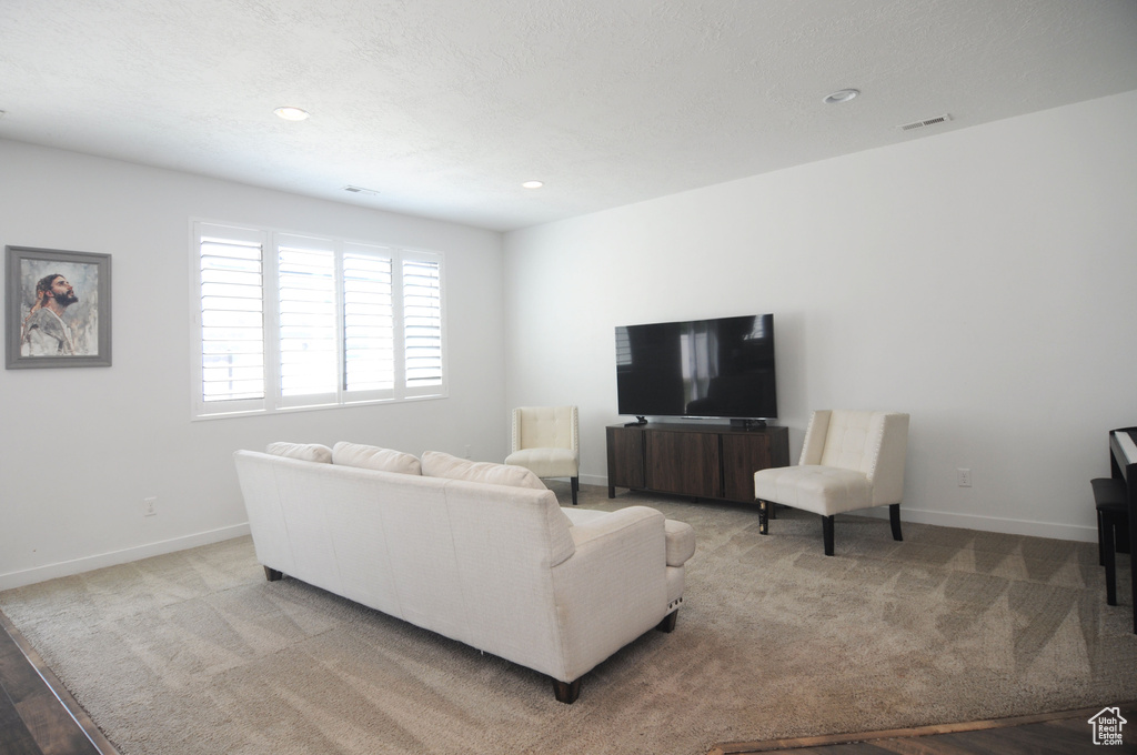 Living room featuring baseboards, recessed lighting, and carpet floors