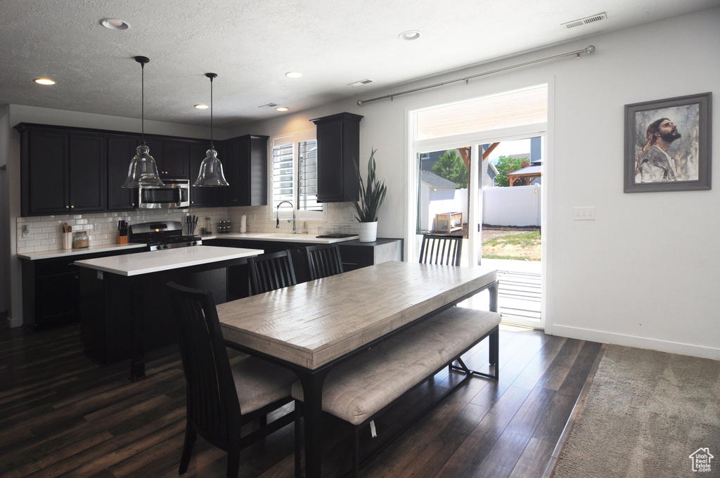 Dining room featuring dark wood-style flooring, recessed lighting, and baseboards