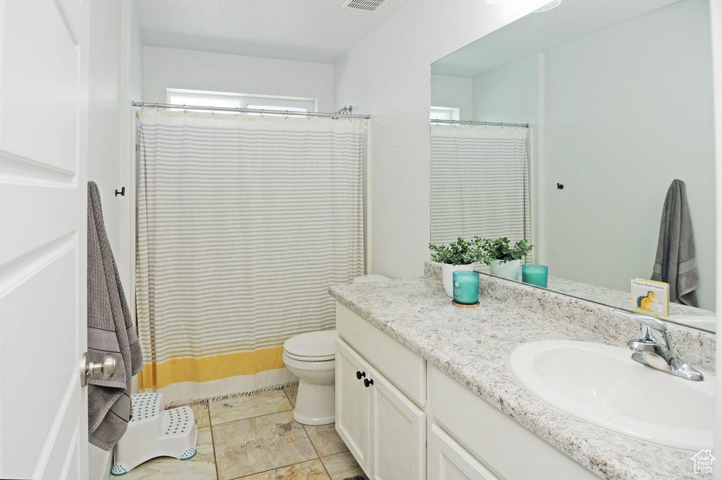 Full bathroom featuring vanity, toilet, and a shower with shower curtain