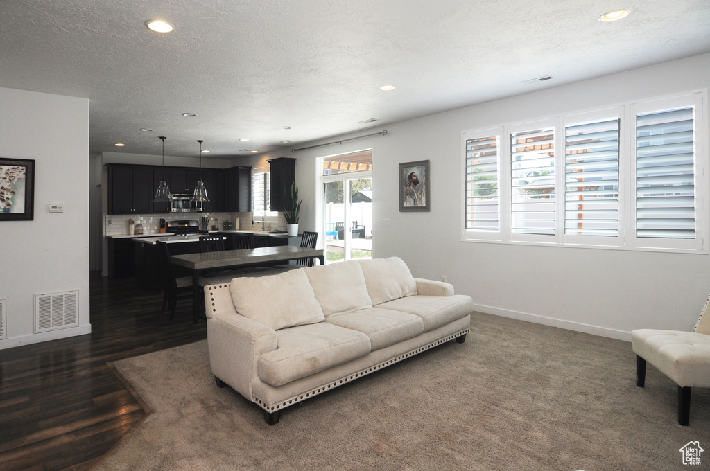 Living room with recessed lighting, baseboards, and dark wood-style floors