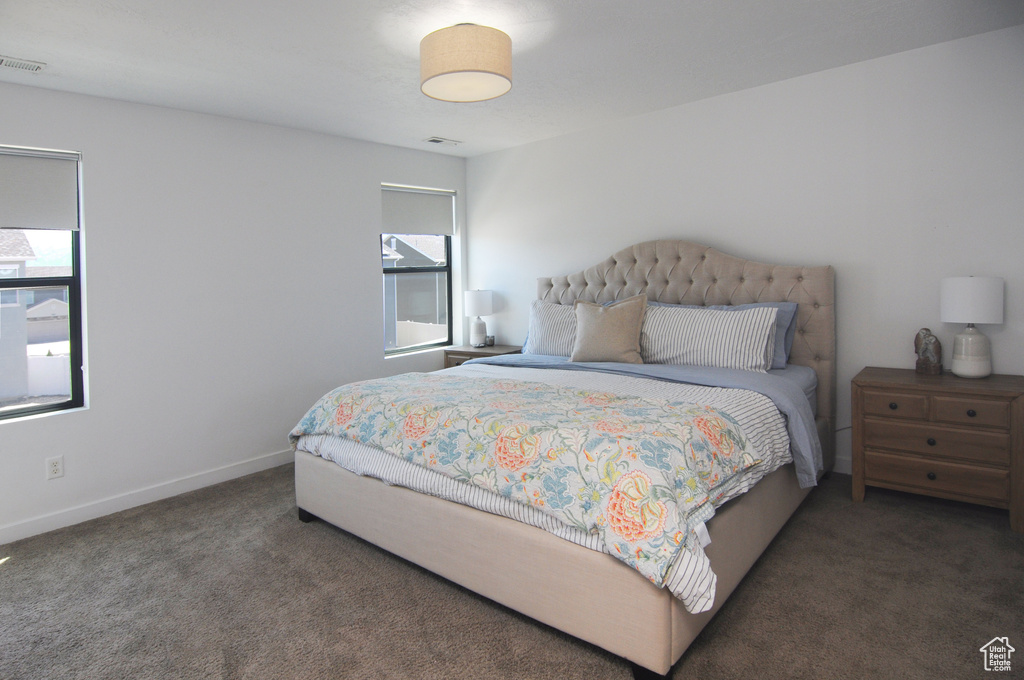 Bedroom featuring carpet and baseboards