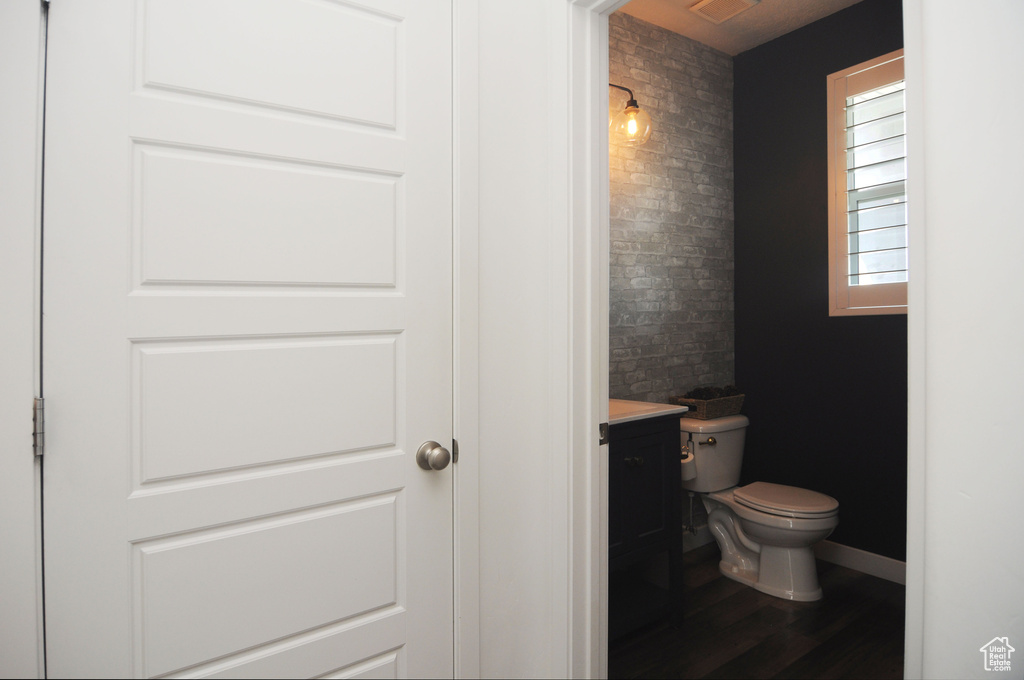 Bathroom with vanity, toilet, and wood finished floors