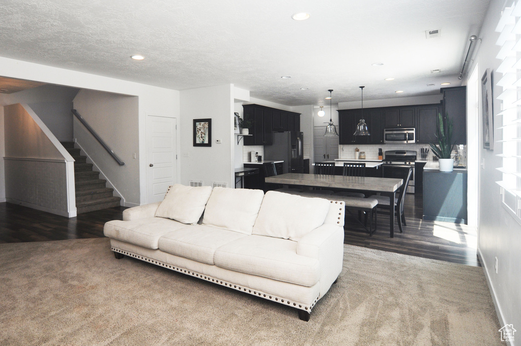 Living room with stairs, baseboards, recessed lighting, and wood finished floors