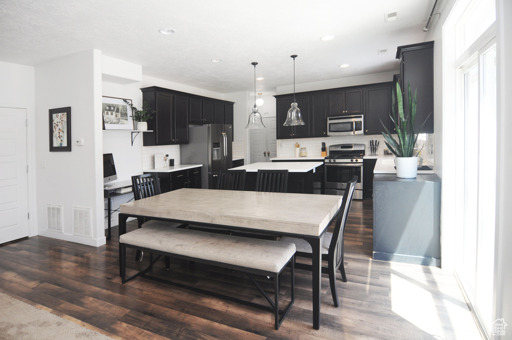 Dining room featuring dark wood-style floors, recessed lighting, and baseboards