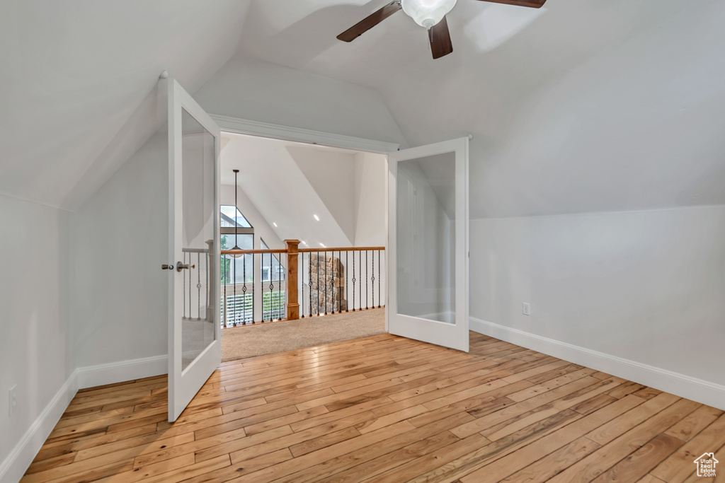 Bonus room with ceiling fan, hardwood / wood-style floors, lofted ceiling, baseboards, and french doors
