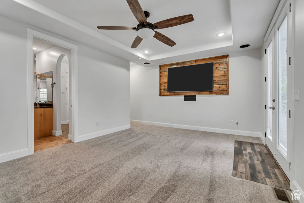 Spare room with ceiling fan, a raised ceiling, carpet, baseboards, and recessed lighting