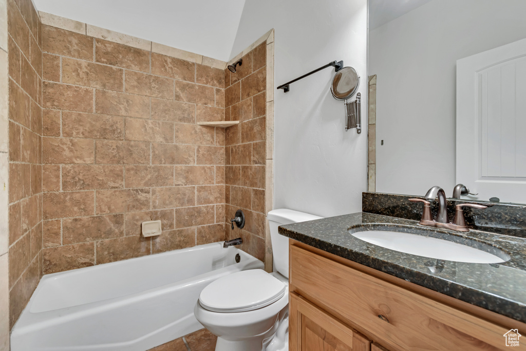 Full bathroom with vanity, toilet, and  shower combination