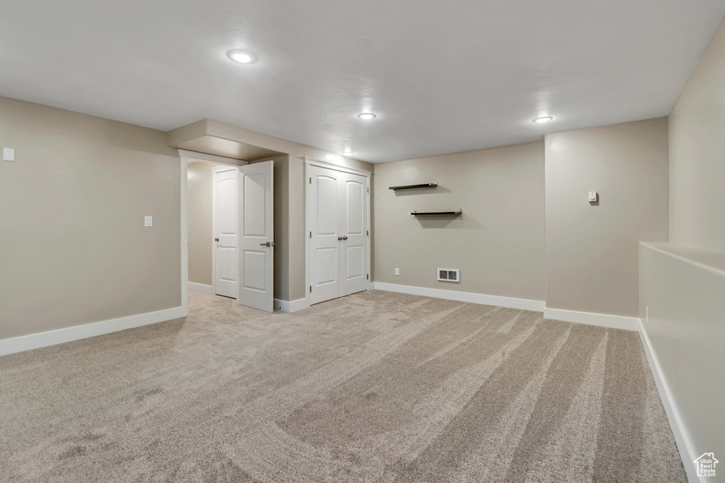 Finished basement with baseboards, light colored carpet, and recessed lighting