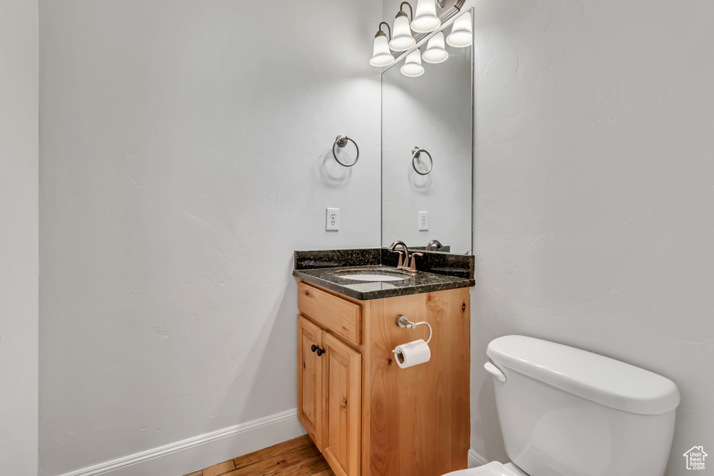Bathroom featuring toilet, vanity, and baseboards