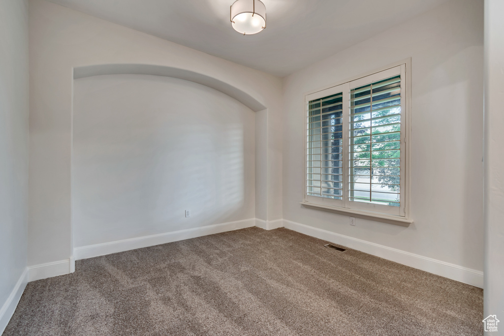 Carpeted empty room featuring baseboards