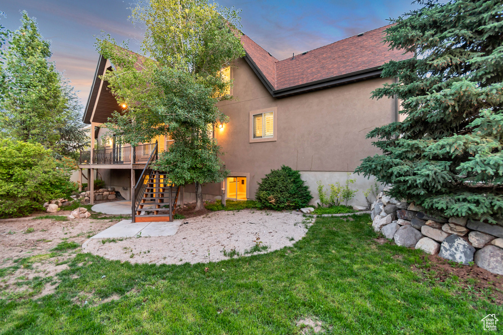 Back of property featuring a patio area, stairway, a deck, stucco siding, and a yard