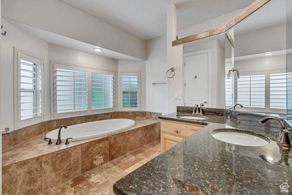 Full bath with double vanity and a bath