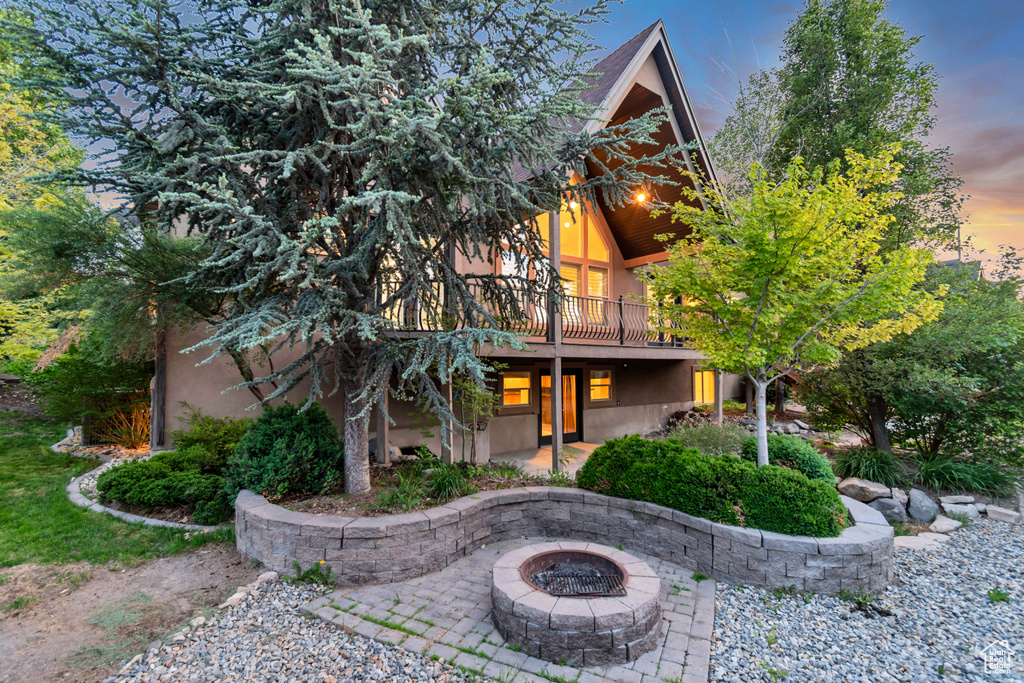 View of front of house with a patio area, an outdoor fire pit, stucco siding, and a deck