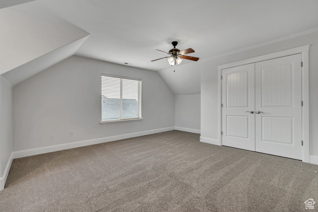 Additional living space with ceiling fan, carpet flooring, lofted ceiling, and baseboards