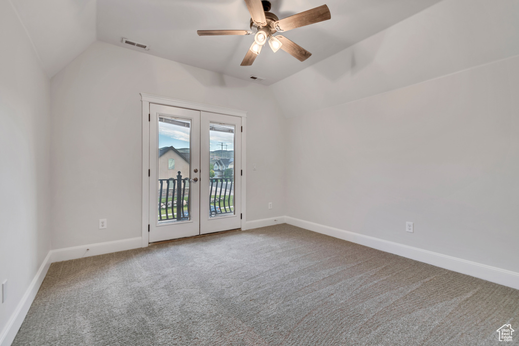 Spare room with vaulted ceiling, french doors, carpet, ceiling fan, and baseboards