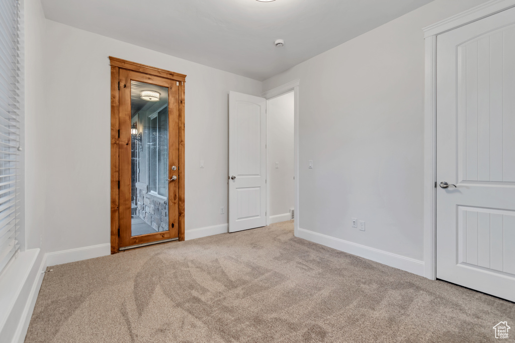 Unfurnished bedroom with carpet floors and baseboards