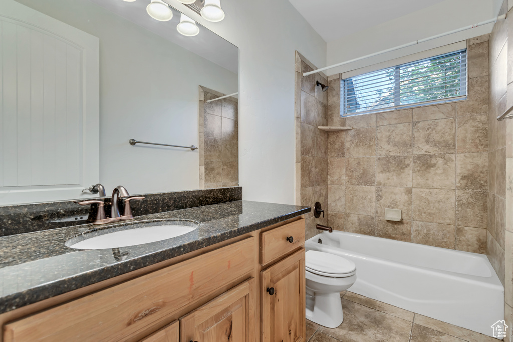 Full bathroom featuring toilet, vanity,  shower combination, and tile patterned floors