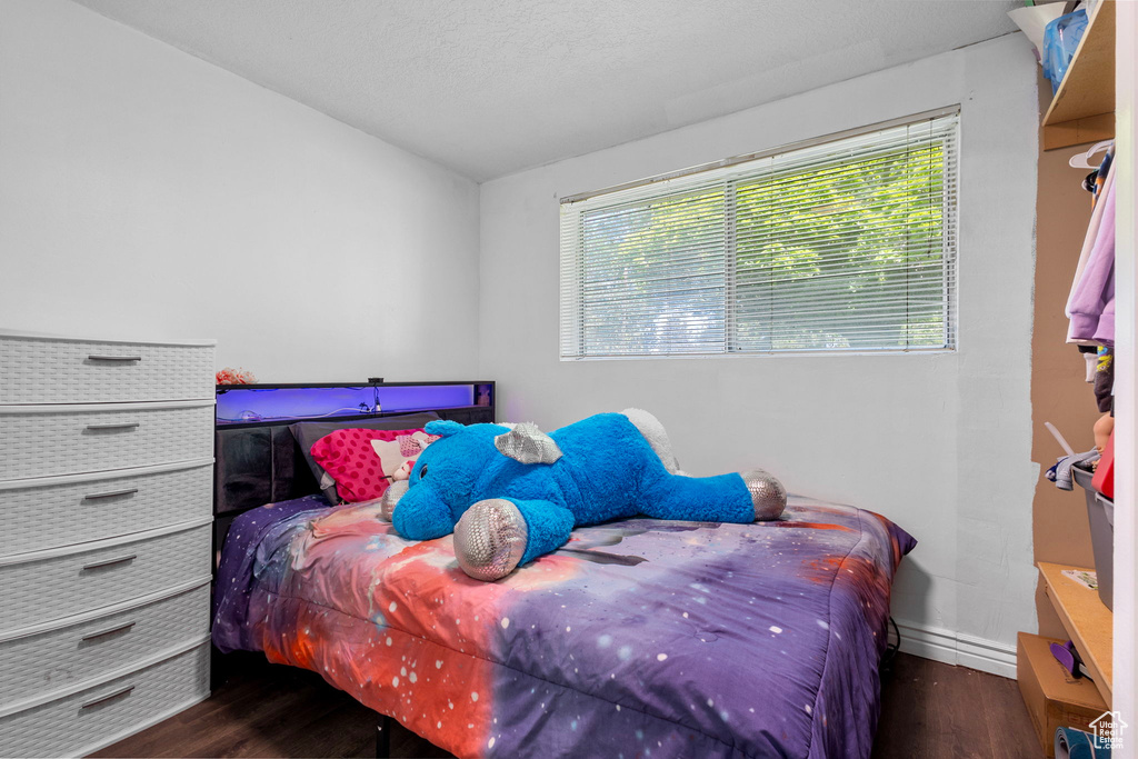 Bedroom with wood finished floors and baseboards