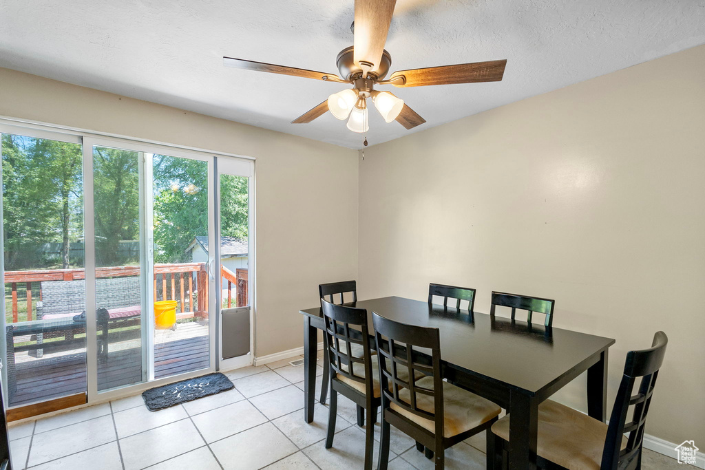 Dining area with ceiling fan, baseboards, and light tile patterned flooring