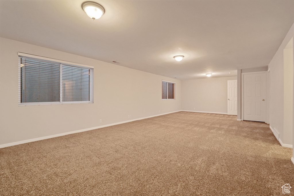 Unfurnished room featuring light colored carpet and baseboards