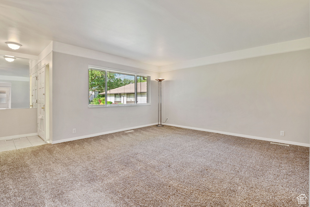 Unfurnished room with light colored carpet and baseboards