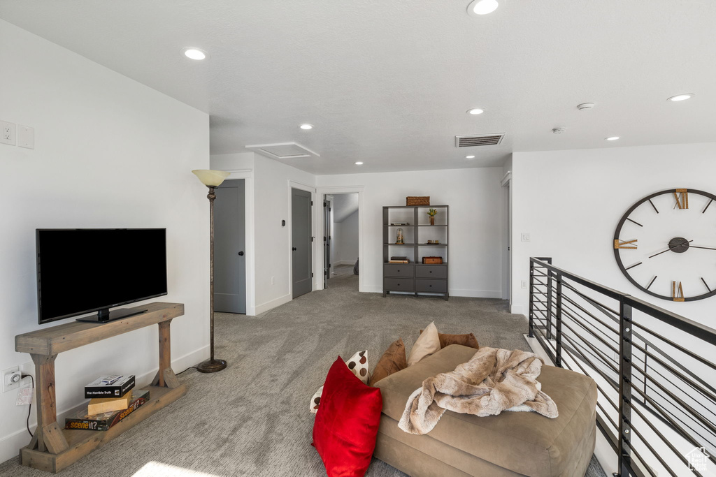 Living area featuring carpet, recessed lighting, baseboards, and attic access