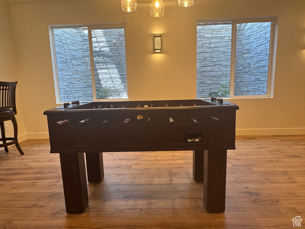 Game room with baseboards and light wood-style floors