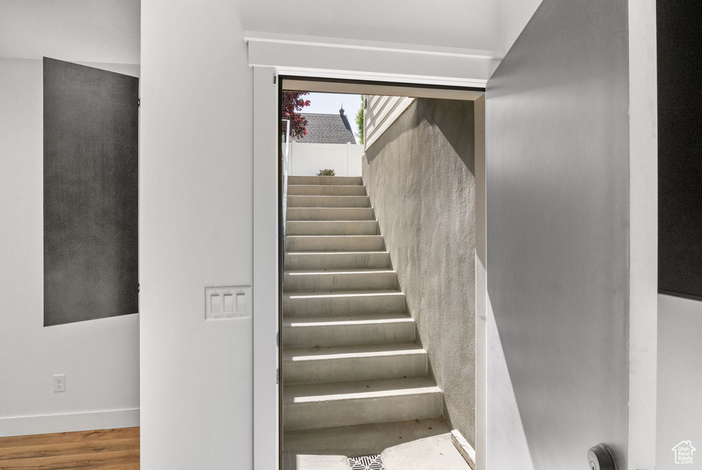 Stairway with baseboards and wood finished floors