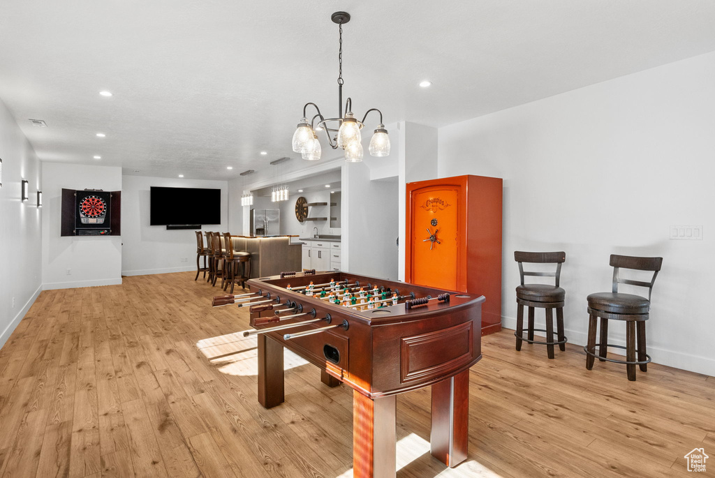 Recreation room featuring light wood-type flooring, recessed lighting, baseboards, and a chandelier