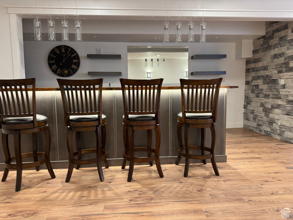 Indoor dry bar featuring wood finished floors and baseboards