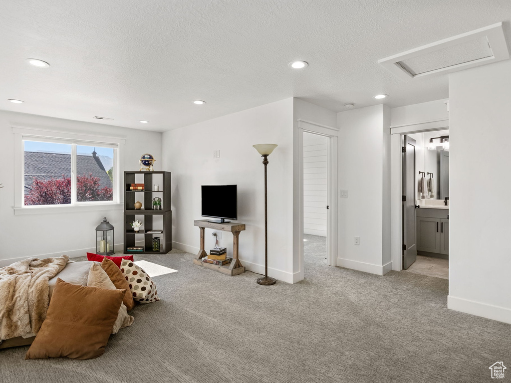 Carpeted living area with recessed lighting, attic access, and baseboards