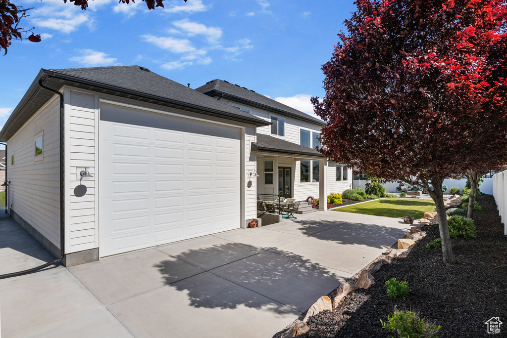 View of front of house featuring concrete driveway and roof with shingles
