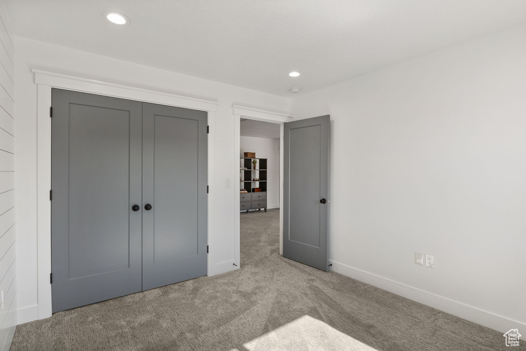 Unfurnished bedroom with carpet, baseboards, recessed lighting, and a closet