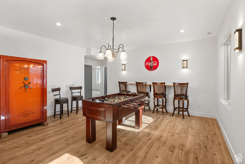 Recreation room featuring light wood-type flooring, a chandelier, baseboards, and recessed lighting