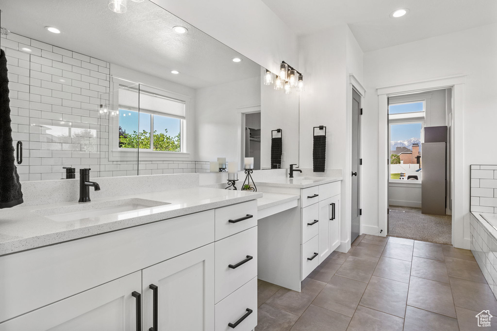 Full bathroom featuring double vanity, healthy amount of natural light, recessed lighting, tile patterned flooring, and baseboards